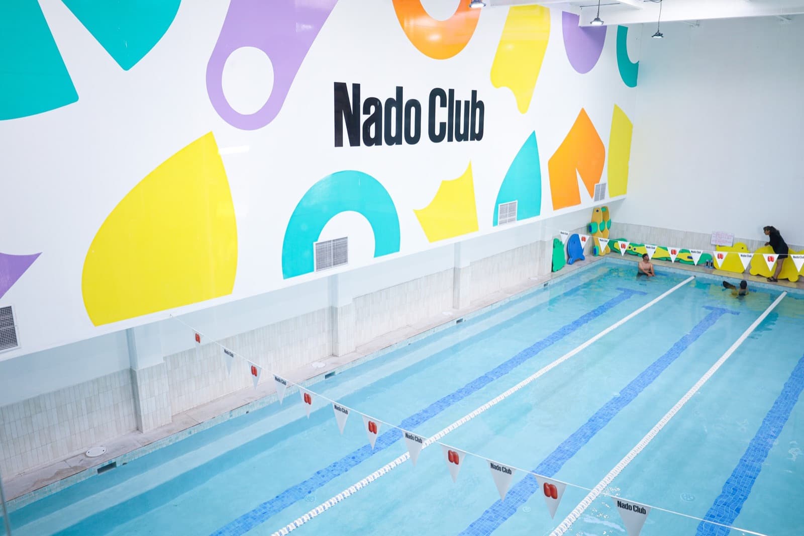 Alberca climatizada de Nado Club con su mural de colores